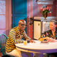 Daniel R. Day, aka “Dapper Dan,” left, and Michaela Angela Davis sit at the kitchen table in SheaMoisture’s “House of Hair” at the 2019 Essence Festival in New Orleans, La. on July 6, 2019